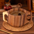 Akazienholz-Tasse mit Doppelgriffen und breiter Schale auf Flechtuntersetzer