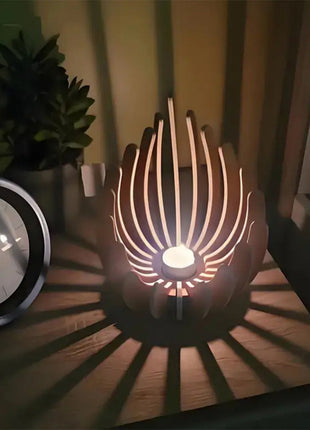 Holz-Kerzenhalter im Lotusdesign mit brennender Kerze, warmes Licht durch Lamellen.