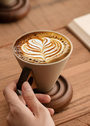 Trichterförmige Keramiktasse mit Kaffee und Spiralsockel aus Holz