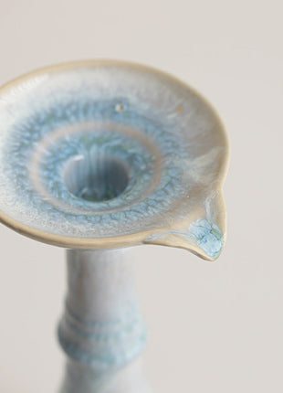 Nahansicht: blau-weiße Kerzenschale mit Reaktivglasur auf Kerzenhalter aus Keramik.