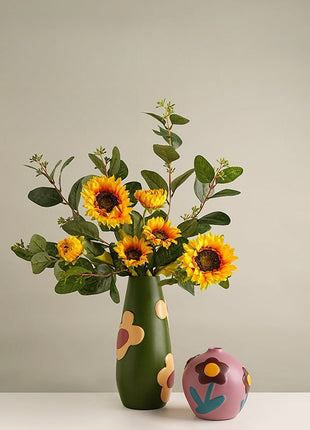 Grüne Keramik-Vase mit Blumenmotiv, mit orange-gelben Sonnenblumen befüllt