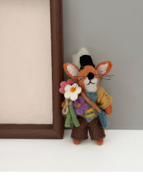 Flower fox wool felt charm beside a wooden frame
