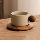 Keramik-Tasse mit Untertasse, beiger Becher mit braunem Knopfgriff und schlichter Oberfläche