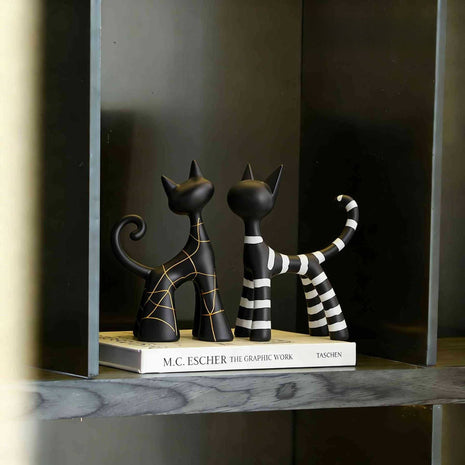 Katzen-Dekofigur auf Ablage: schwarze Figuren, gestreifter Schwanz und goldene Linien