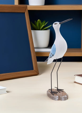 Stehende Möwen-Dekofigur: weißer Vogel mit blauem Flügel, auf Metallbeinen und Holzsockel.