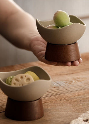 Keramik-Dessertschale auf Standfuß in Hand gehalten, cremefarbenes Schälchen, braune Basis