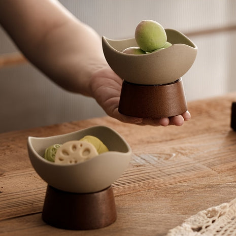 Keramik-Dessertschale auf Standfuß in Hand gehalten, cremefarbenes Schälchen, braune Basis