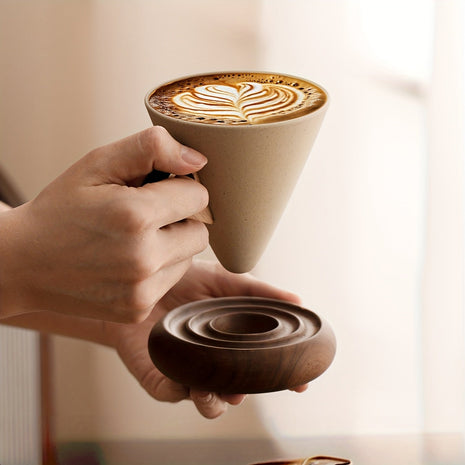 Trichterförmige Keramiktasse mit Kaffee und Spiralsockel aus Holz