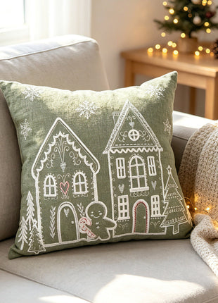 Light green square Christmas village pillow beside a Christmas tree