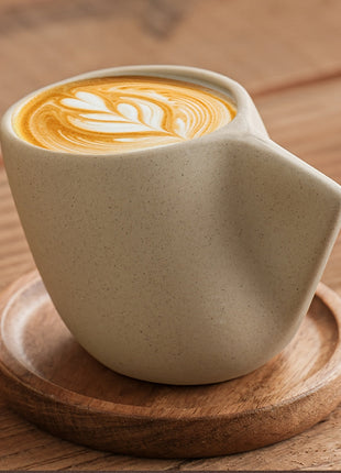 Steingut-Kaffeetasse mit Holzuntersetzer, geschwungener Griff, Latte-Art in der Tasse
