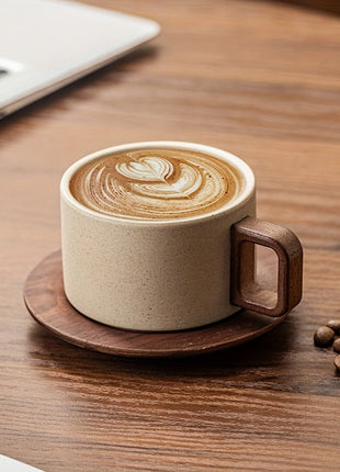 Beige Keramiktasse auf Holzuntersetzer mit Latte-Art und Kaffeebohnen