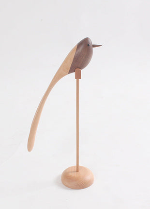 Holzvogel-Deko mit langem Schwanz auf rundem Sockel, dunkler Vogel, seitliche Ansicht