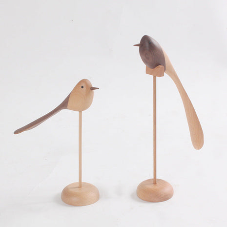 Holzvogel-Deko mit langem Schwanz auf rundem Sockel, helles Holz