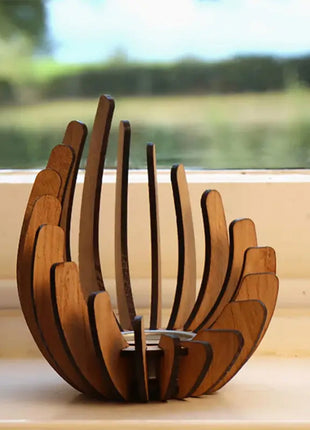 Holz-Kerzenhalter im Lotusdesign mit brennender Kerze am Fensterbrett.