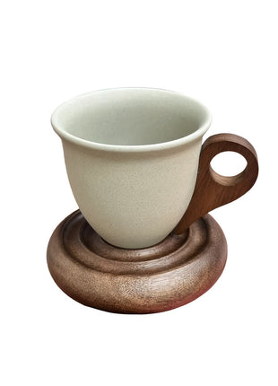 Kaffeetasse aus Keramik mit Holzuntersetzer, hellbeige Tasse und brauner Untersetzer