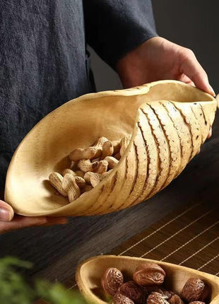 Obstschale aus Bambuswurzel in Bootform, mit Nüssen, von Hand gehalten