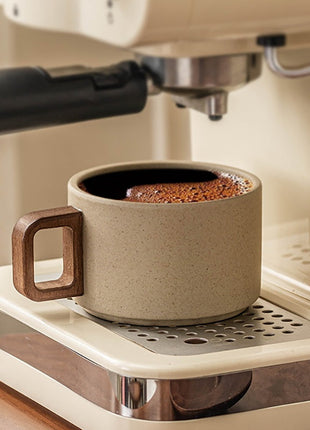 Beige Keramiktasse mit Holzuntersetzer, brauner Kaffee im Inneren