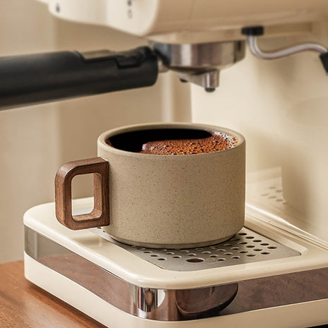 Beige Keramiktasse mit Holzuntersetzer, brauner Kaffee im Inneren