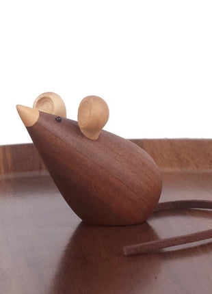 Holzmaus auf Holzplatte, liegende Figur mit dunkler Ohrpartie