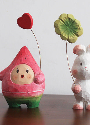 Holzfigur: roter Wassermelonen-Mensch mit rotem Herzballon und grüner Basis