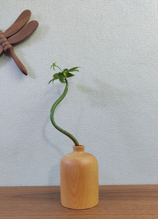 Kleine Holzvase aus Buchenholz mit schmaler Öffnung und geriffelter Oberfläche, auf Tisch