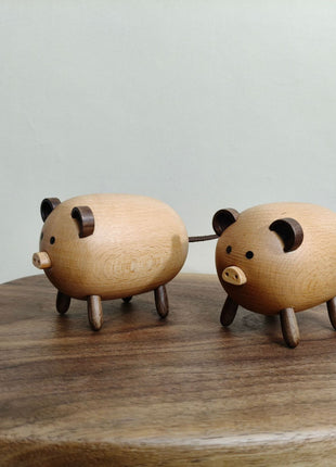 Zwei Massivholz-Schweinchen nebeneinander, runde Ohren und Holzbeine, Tierfiguren