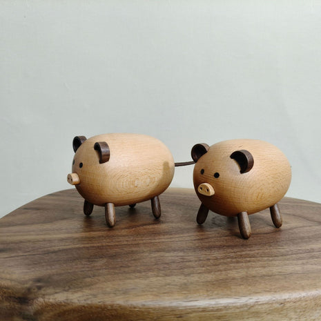 Zwei Massivholz-Schweinchen nebeneinander, runde Ohren und Holzbeine, Tierfiguren