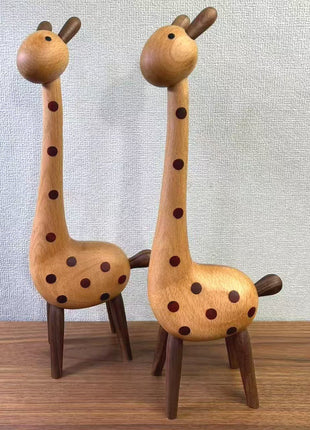 Zwei Holz-Giraffenfiguren nebeneinander, braune Punkte und dunkle Beine