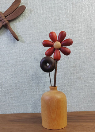 Kleine Holzvase aus Buchenholz mit runder Öffnung, bestückt mit roter Blüten-Deko