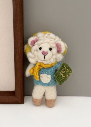 Reading sheep wool felt charm beside a wooden frame