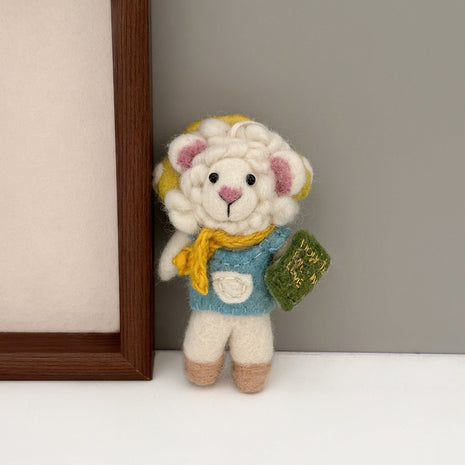 Reading sheep wool felt charm beside a wooden frame