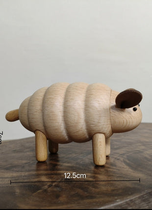 Schaf aus hellem Buchenholz mit braunen Ohren und schwarzem Auge, Figur im Seitenprofil.