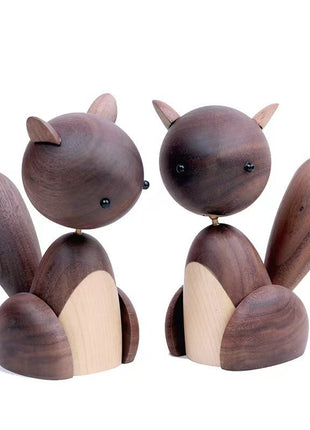Holzfigur Eichhörnchen aus dunklem Holz, zwei sitzende Figuren mit hellem Bauch auf Sockel