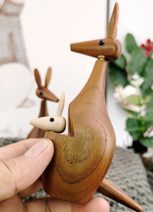 Holz-Känguru-Dekofigur, Hand hält die Figur; braunes Holz mit kleinem Känguru