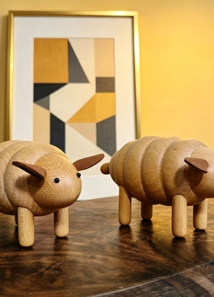 Zwei Schaf-Figuren aus Buchenholz, nebeneinander mit braunen Ohren und schwarzen Augen.