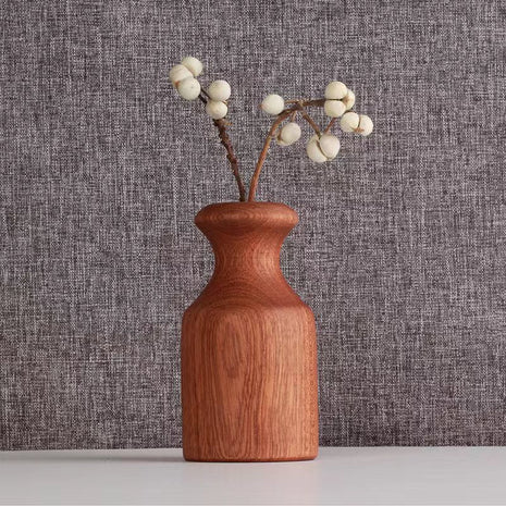 Holzvase aus Massivholz: schlanke, bauchige Vase in rötlich-braun mit Trockenblumen-Zweig