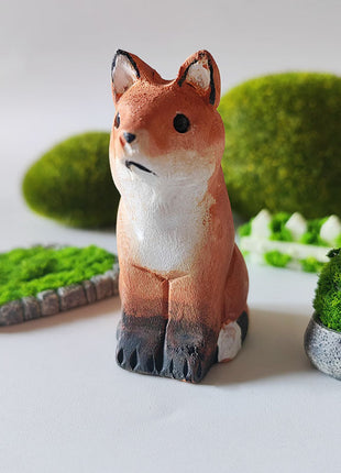 Handgeschnitzte Holzfigur Hund aus Massivholz, orange-weiße Bemalung, hockende Pose