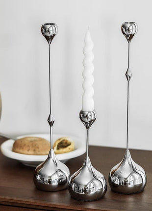 Tropfen-Kerzenhalter-Set aus silbernem Metall, drei Tropfenfüße auf einer Holzfläche