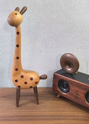 Giraffenfigur aus Holz neben Spielzeugauto, braune Punkte auf hellem Körper