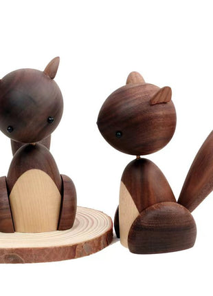 Holzfigur Eichhörnchen, zwei Figuren aus dunklem Holz mit hellem Bauch, auf Holzscheibe