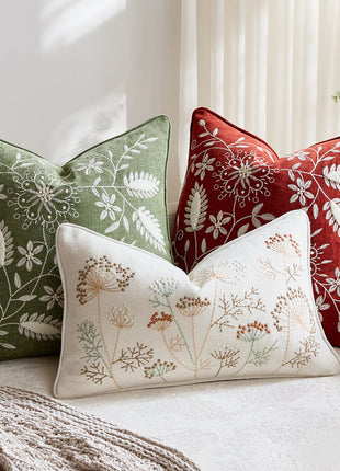Botanical embroidered chenille pillow covers on a cream sofa