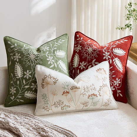Botanical embroidered chenille pillow covers on a cream sofa