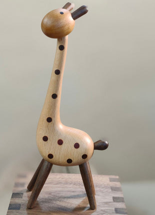 Giraffenfigur aus Holz in ganzer Ansicht, braune Punkte und dunkle Beine