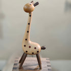 Giraffenfigur aus Holz in ganzer Ansicht, braune Punkte und dunkle Beine