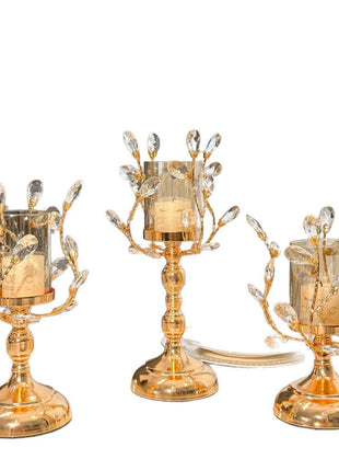 Drei goldene Glas-Kerzenhalter mit Kristallbesatz auf weißem Hintergrund, klarer Standfuß