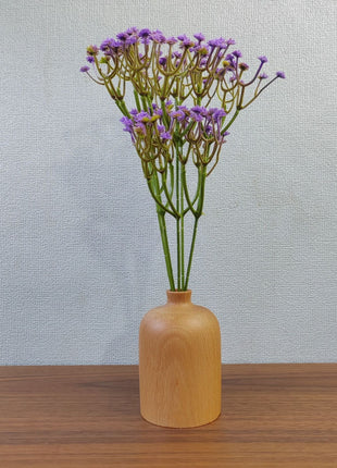Kleine Holzvase aus Buchenholz mit runder Silhouette und breiter Öffnung, auf Tisch