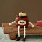 Glückliche Persimone-Holzfigur mit Kulleraugen, rotem Körper und beigen Armen