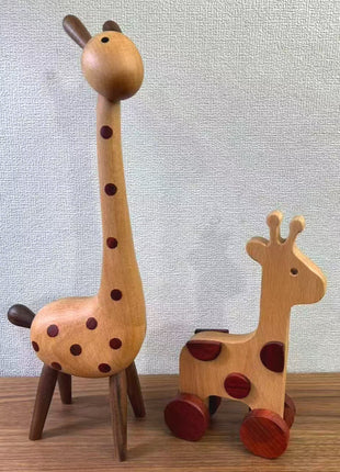 Zwei Holz-Giraffenfiguren, eine vorne, braune Punkte auf hellem Holz