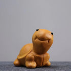 Lächelnde Schildkröten-Holzfigur aus hellgelbem Holz, nach vorn gekehrt im Stand.