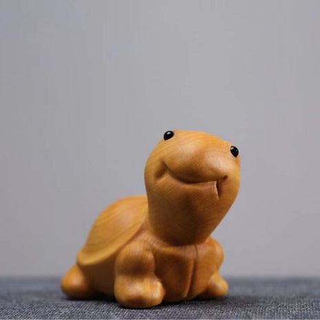 Lächelnde Schildkröten-Holzfigur aus hellgelbem Holz, nach vorn gekehrt im Stand.